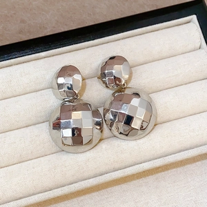 Makroaufnahme von silbernen Ohrsteckern mit geometrisch facettierten Kugeln in Box