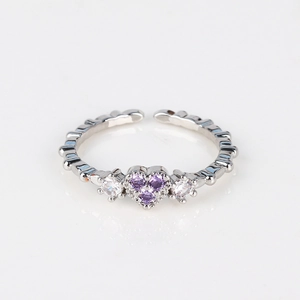 Detail of silver heart ring with purple and white zirconias on textured open band