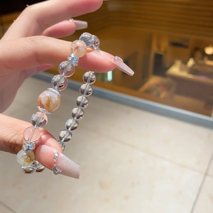 Macro shot of natural crystal bracelet featuring translucent quartz and silver gear spacers
