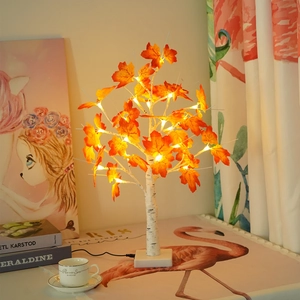 Cozy home decor featuring an autumn maple tree lamp with warm LED lights on a table