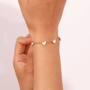 Detail of 18K gold plated stainless steel bracelet with white heart mother of pearl charms
