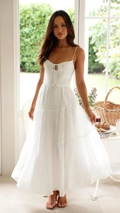 Détail de la robe blanche à bretelles avec buste à cordon et jupe longue à volants