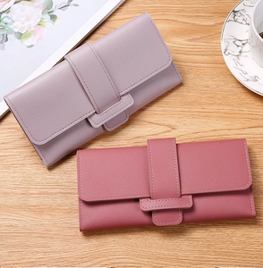 Detail of elegant long flap wallets in lavender and rose pink with litchi grain texture