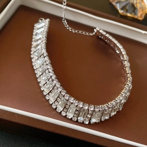 Macro detail of silver choker with multi-row rectangular and round cut crystals