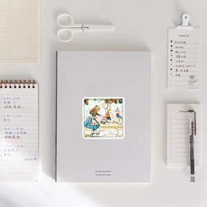Close-up of vintage Alice in Wonderland Christmas sticker on a white notebook