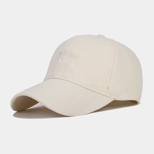 Close-up of smile embroidery on the crown of a beige cotton twill baseball cap