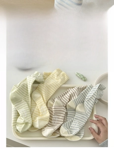 Detailed view of four pairs of striped cotton crew socks in assorted pastel colors