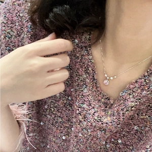 Elegant close-up of a pink round cubic zirconia necklace on a model wearing pink lace