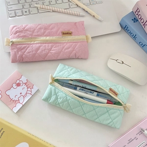 Detailed view of quilted nylon pencil cases in pink and mint green with smooth zippers
