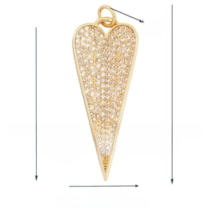 Macro detail of a 18K gold plated long heart pendant with pave set zircon stones