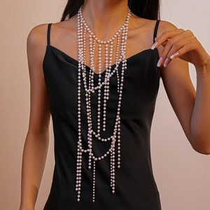 Detailed close-up of multilayer pearl body chain with cascading tassel beads on a model
