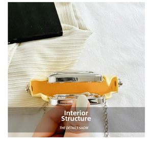 Detail view of mini yellow chain bag with silver frame showing internal single compartment