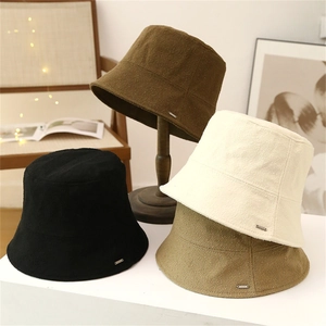Women's minimalist wool bucket hats in four colors with small metal logo plate