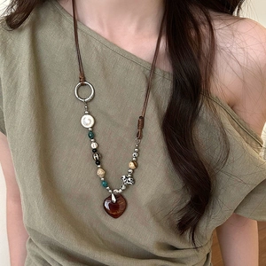 Close-up of vintage beaded ethnic necklace with an amber heart pendant on model