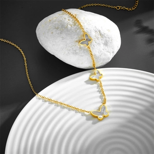 Golden butterfly necklace with shell inlay on a stone display for an elegant look
