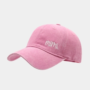 Close-up of vintage pink washed cotton baseball cap with white mimi script embroidery