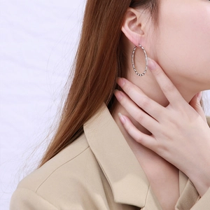Minimalist silver bamboo texture hoop earrings for women shown on model profile