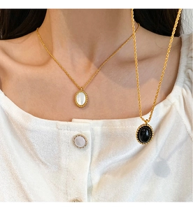 Detail of French vintage necklaces with oval black onyx and white mother of pearl pendants