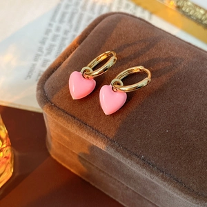 Detail of vintage pink enamel heart earrings resting on a brown velvet jewelry box