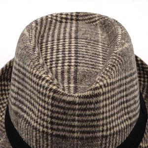 Macro detail of retro plaid wool felt fedora with stylish black decorative band texture