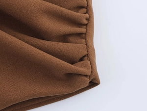 Vue macro détaillée du tissu crêpe marron avec des plis froncés et des volants fins