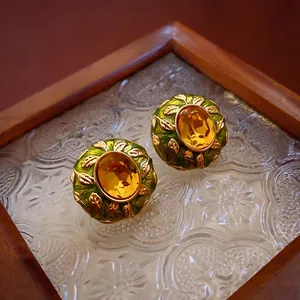 Vintage gold-plated oval earrings with amber gemstone and green enamel leaf accents