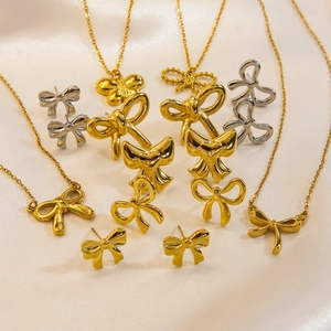 Makroaufnahme von Goldschmuck-Schleifen-Kollektion auf weichem Seidenhintergrund