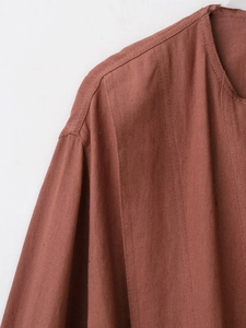 Detail shot of rust red faux suede jacket showing collar and cotton linen texture