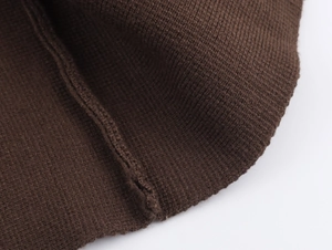 Vista macro del tessuto a maglia marrone scuro con cuciture fini e trama di alta qualità