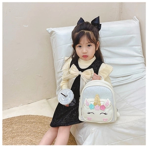 Toddler girl modeling cute white unicorn sequin backpack with 3D ears and gold horn