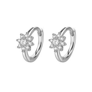 Macro shot of silver zircon flower ear cuff with sparkling stones on grey background