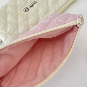 Detail view of pink quilted cosmetic bag showing spacious interior and diamond pattern