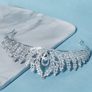 Detail of silver bridal tiara with leaf design and teardrop pendant on marble