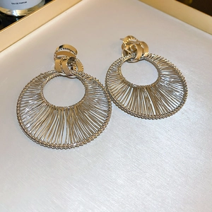 Macro detail of silver geometric woven hoop earrings with polished metal texture