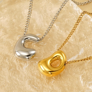 Detailed macro shot of golden and silver bean-shaped pendants on fine metal chains