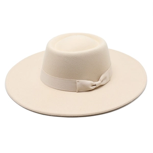 Détail d'un chapeau de feutre crème avec large bord plat et ruban décoratif élégant