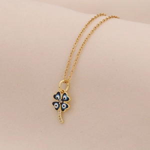 Macro shot of gold stainless steel necklace with blue Evil Eye four-leaf clover pendant