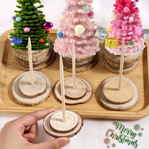 Close-up of a hand holding a wooden base for DIY plush pipe cleaner Christmas trees