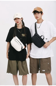 Detail view of black and white minimalist nylon crossbody bags with orange side labels