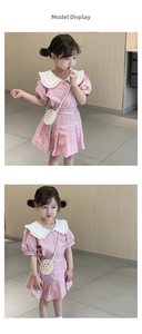 Girl's pink pleated skirt and shirt set with a large ruffled collar and pearl woven bag