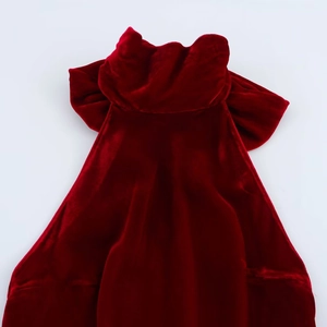 Vue détaillée d'une cape en velours rouge foncé avec un grand nœud au dos