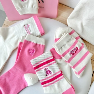 Detail of pink and white striped cotton socks with cute bear and heart embroidery