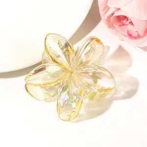 Macro view of translucent iridescent flower hair claw clip with golden metal spring
