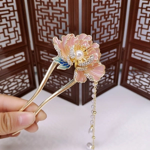 Pink peony hair stick with pearl tassels held against a traditional Chinese screen