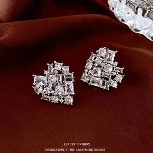 Elegant silver heart earrings with sparkling cubic zirconia on a deep silk background