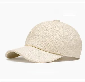 Detail of off-white straw woven baseball cap showing breathable texture and curved brim