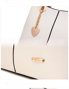 Detail of white leather tote with champagne gold heart pendant and Forever metal plate