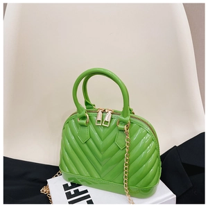 Detail of bright green jelly shell bag with V-shaped texture and gold metal chain