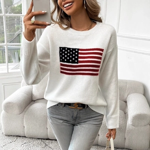 Close-up of white knit sweater featuring an American flag intarsia pattern on the chest