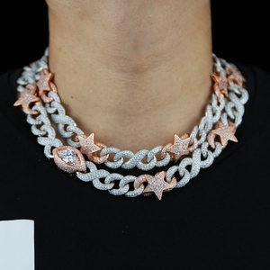 Close-up of iced-out hiphop chains with star and evil eye pendants on a male model